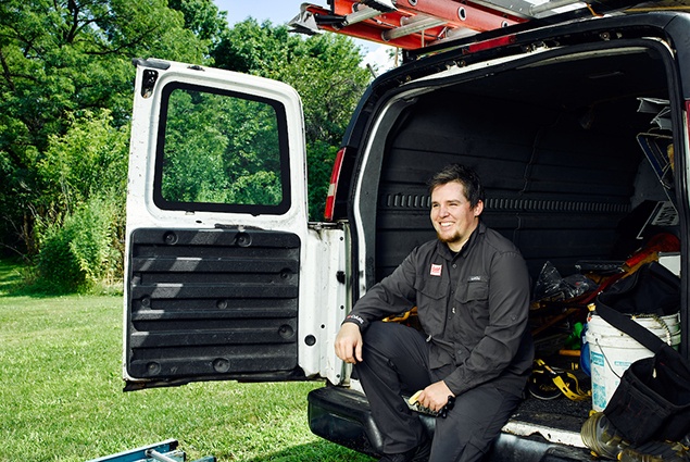 GAF employee sitting in the back of a work van