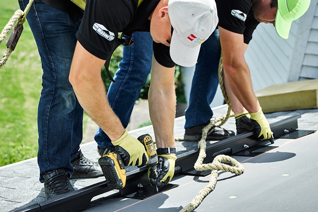 Two GAF Master Elite Solar decotech installers on shingle roof