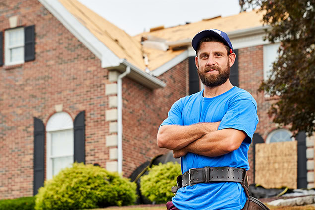 A solar roof contractor standing in front of a house during a solar roof installation